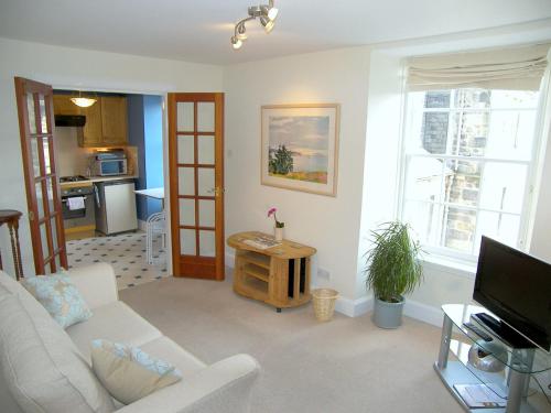 - un salon avec un canapé et une télévision dans l'établissement Royal Mile Apartment, à Édimbourg