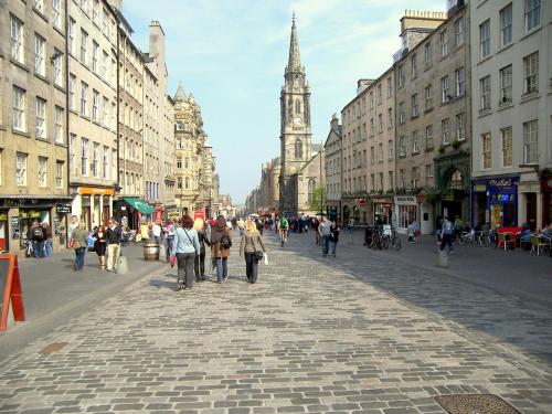 a group of people walking down a city street at Royal Mile Apartment in Edinburgh