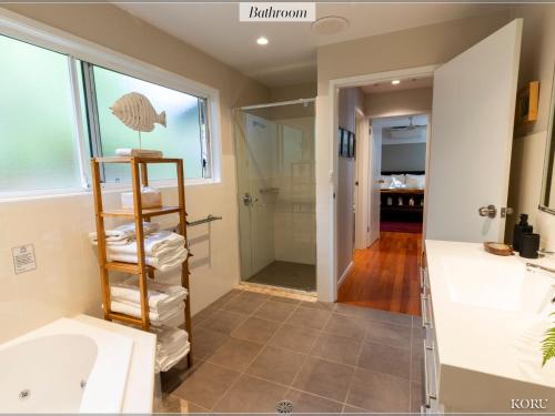 a bathroom with a sink and a bath tub at Koru at Hyams Beach in Hyams Beach