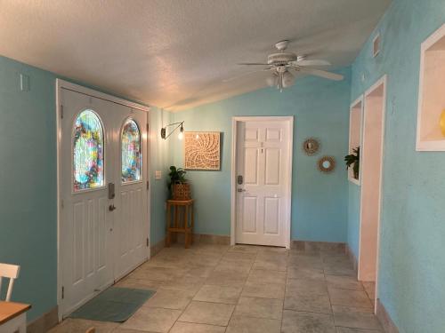 a hallway with blue walls and a ceiling fan at 3Gulls Inn Ozona-Boutique Hotel-Steps from Restaurants & Brewery-SwimSpa Pool-Pet Friendly in Palm Harbor