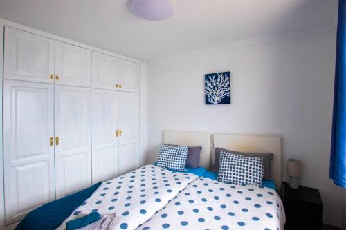 1 dormitorio con 1 cama con almohadas azules y blancas en OCEAN tiny HOUSE en Casa azul, en Punta Mujeres