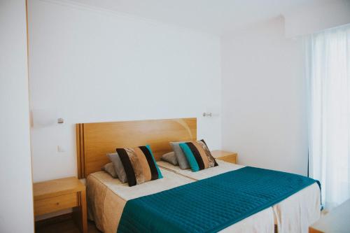 um quarto com uma cama com um edredão verde e branco em Casa da Capelinha em Ponta Delgada