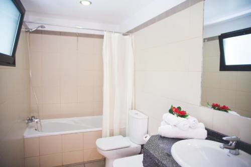 a bathroom with a sink and a toilet and a tub at Casa da Capelinha in Ponta Delgada