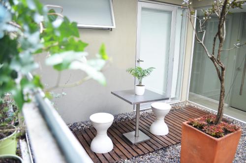 a patio with a table and two potted plants at Hotel Living 55 in Bogotá