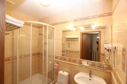 a bathroom with a sink and a shower and a toilet at Hotel Janusz in Siedlce