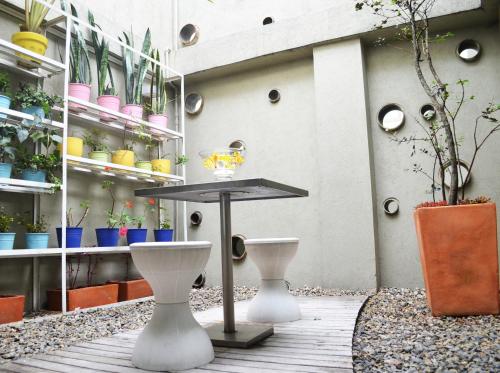 a patio with a table and some potted plants at Hotel Living 55 in Bogotá