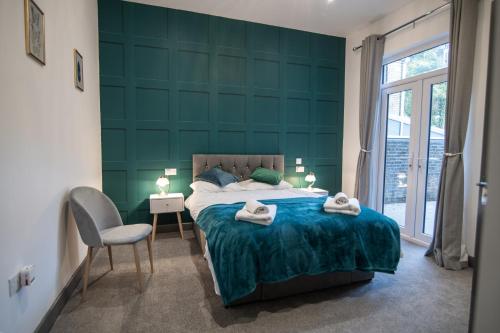 a green bedroom with a bed and a chair at Cheerful 6 Bed with Hot Tub @ The Grey Elegance in Kent