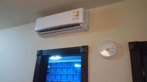 a air conditioner and a clock on a wall at شاليهات بورتو مطروح فيو بحر Porto Matrouh Sea View Families Only in Marsa Matruh
