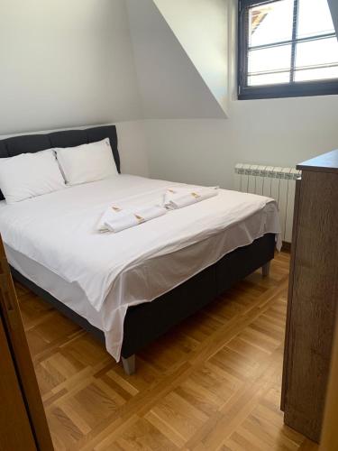 a bed with white sheets and pillows in a room at Mountain Villa Zlatibor in Zlatibor
