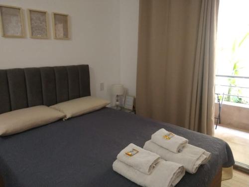 a bedroom with a bed with towels on it at Aires Verdes Salta in Salta