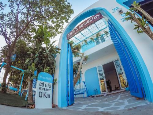 a blue and white building with an archway at Cô Tư's Homestay in Phan Thiet