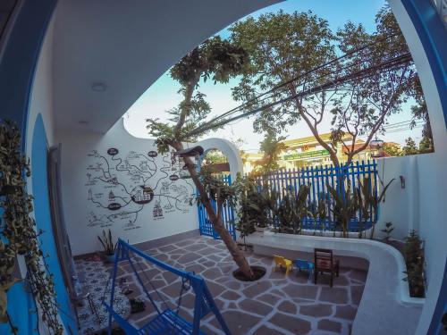 an arched hallway with a tree mural on the wall at Cô Tư's Homestay in Phan Thiet
