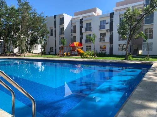a swimming pool in front of a building at Departamento 2 habitaciones con vista a la piscina by EITA in Cancún