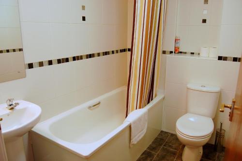 a white bathroom with a toilet and a sink at Royal Mile Apartment in Edinburgh