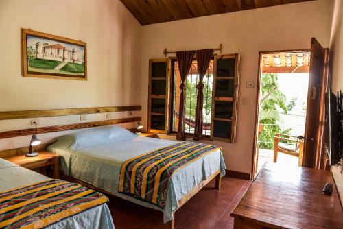 a bedroom with two beds and a sliding glass door at Hotel and Restaurant Guancascos in Gracias