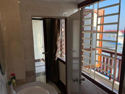 a bathroom with a sink and a large window at Queenwood Hotel in Phnom Penh