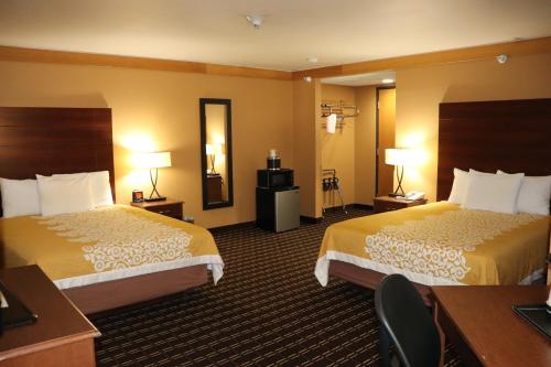 a hotel room with two beds and a desk at Prairie Inn Holmen La Crosse Area in Holmen