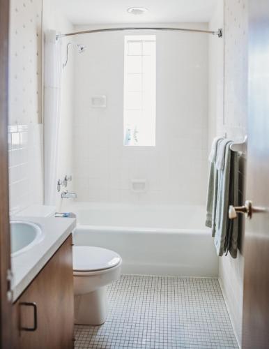 a white bathroom with a toilet and a sink at Hotel Phillips in Bartlesville