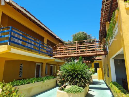 un edificio de apartamentos con balcón y plantas en Pousada e Restaurante Sombra dos Coqueiros en Trairi