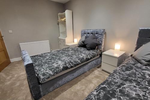 a bedroom with two beds and a dresser with lights at Kepler Residence Modern 4 Bedroom Property 1 mile from Leeds Centre in Leeds