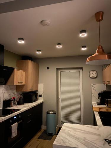 a kitchen with a sink and a clock on the ceiling at Lovely 3 bed with jacuzzi, close to airport, driveway, wifi in Edinburgh