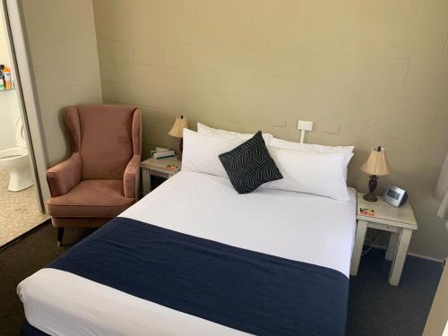a hotel room with a bed and a chair at Gulgong Motel in Gulgong