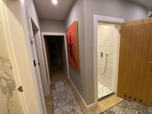 a bathroom with a shower and a painting on the wall at Lovely 3 bed with jacuzzi, close to airport, driveway, wifi in Edinburgh