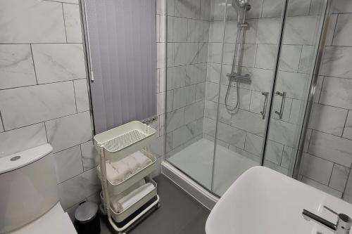 a bathroom with a shower and a toilet and a sink at Kepler Residence Modern 4 Bedroom Property 1 mile from Leeds Centre in Leeds