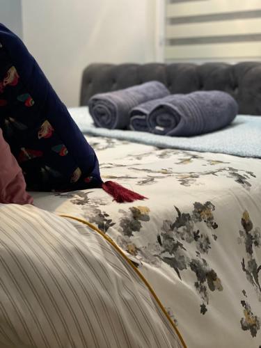 a bed with a blanket and pillows on it at Lovely 3 bed with jacuzzi, close to airport, driveway, wifi in Edinburgh