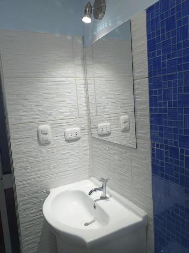 a bathroom with a sink and a mirror at Chakana Family Home 2 Lima Airport in Lima