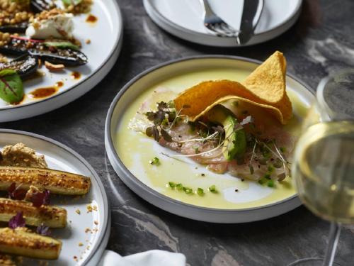 a table with plates of food and glasses of wine at Kyah in Blackheath