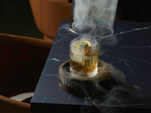 a glass of tea on a table with smoke at Kyah in Blackheath