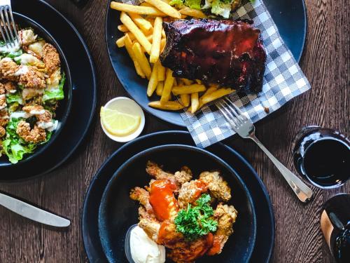 a table with two plates of food and french fries at Mid City Motel Warrnambool in Warrnambool