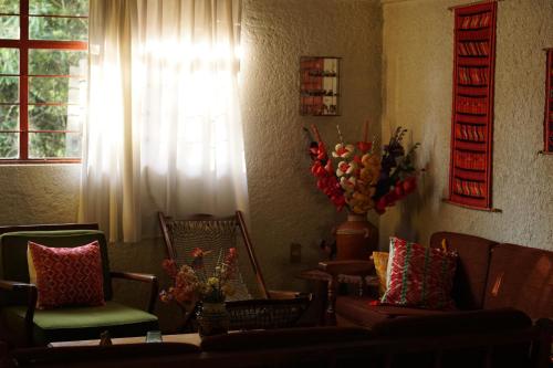 - un salon avec des chaises, un canapé et une fenêtre dans l'établissement Hogar a las afueras del Parque Nacional El Chico., à Mineral del Chico
