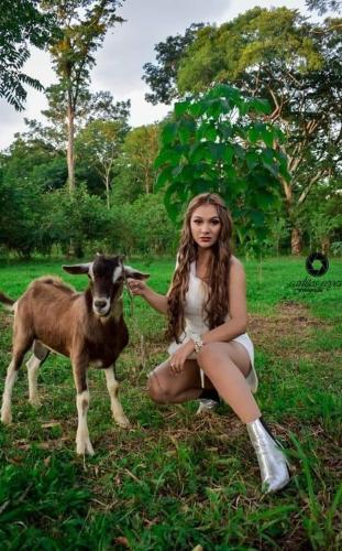 a woman is petting a goat in a field at ECO HOTEL LACHUA in Cobán