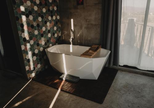 a white bath tub in a bathroom with a window at The Pangea Valle de Guadalupe in Valle de Guadalupe
