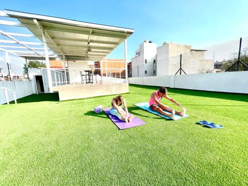 two people are doing yoga on the grass at Downtown Treasure Place in Mexico City