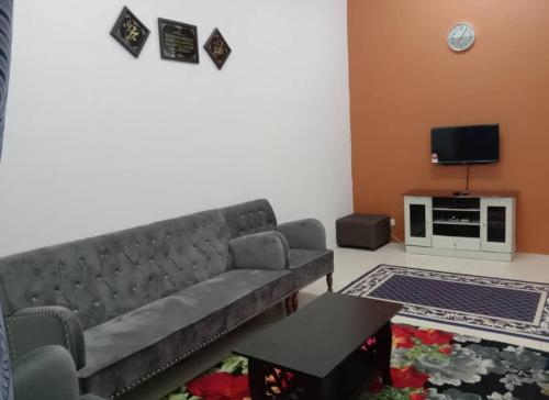 a living room with a couch and a tv at YIE HOMESTAY muslim friendly in Kampong Bukit Dukong