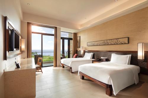 a hotel room with two beds and a television at Wanda Realm Resort Sanya Haitang Bay in Sanya