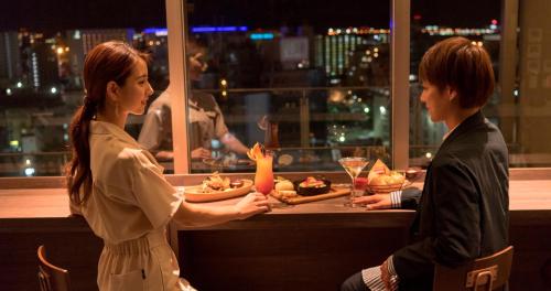 two women standing in a restaurant holding plates of food at HOTEL SANSUI NAHA Ryukyu Onsen Naminoue-No-Yu in Naha