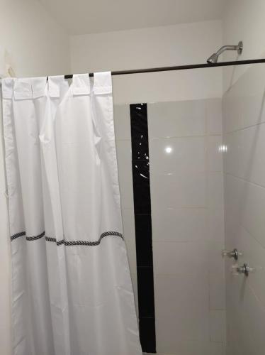 a bathroom with white curtains and a shower at HOTEL BLACK & WHITE in Cali