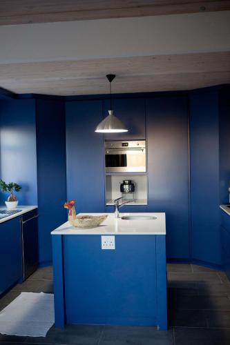 a blue kitchen with a sink and a stove at Villa Del Mar in Clareport
