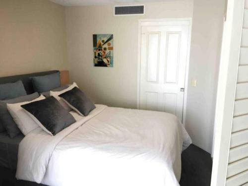 a bedroom with a large bed with white sheets at Beach apartment with all the facilities you need - Landmark Resort in Mooloolaba