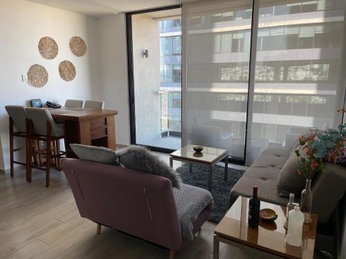 a living room with a couch and a table at Motto, Queretaro Departamento in Miranda