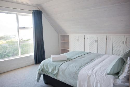 Un dormitorio con una cama y una ventana grande. en Villa Del Mar, en Clareport