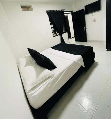 a large bed with black and white sheets and pillows at HOTEL BLACK & WHITE in Cali