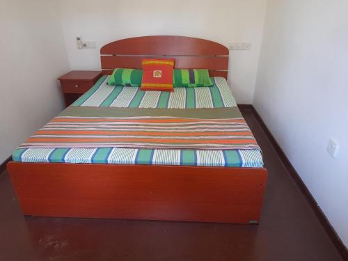 a bedroom with a wooden bed with a book on it at Princely House Apartment in Galle