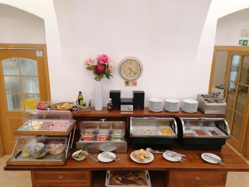 a buffet with food and a clock on the wall at Hotel Belcredi in Brno