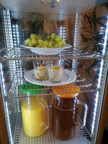 a refrigerator with a plate of food and a plate of fruit at Hotel Belcredi in Brno