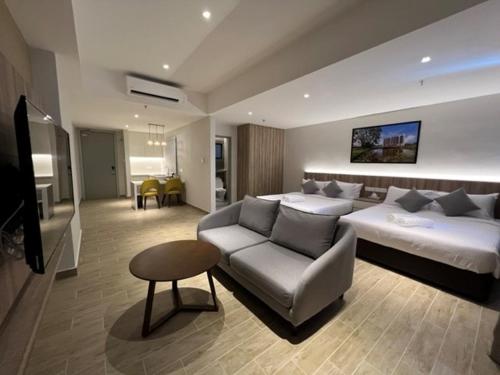 ein Schlafzimmer mit einem Bett, einer Couch und einem Tisch in der Unterkunft Amverton Cove Golf & Island Resort in Banting